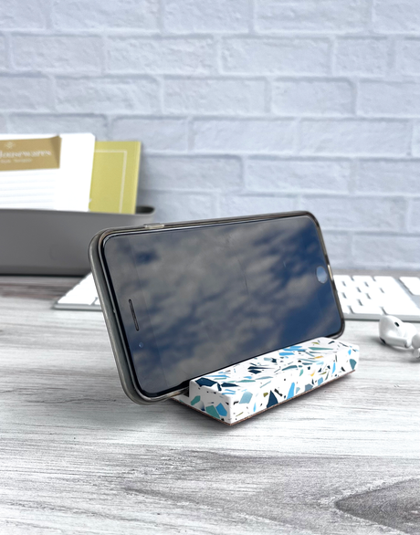 a terrazzo rectangular phone holder with shades of purple blue and green